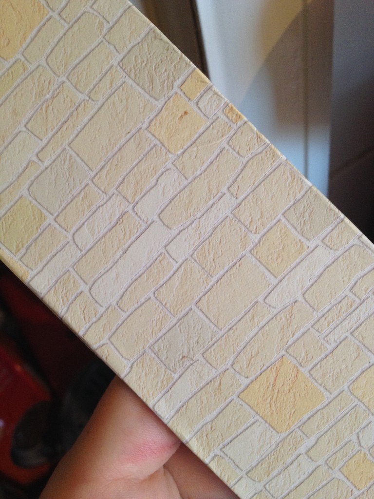 Brick style dollhouse paper, which you can find online or in a crafting store, for the wooden panels that made up the bricks.